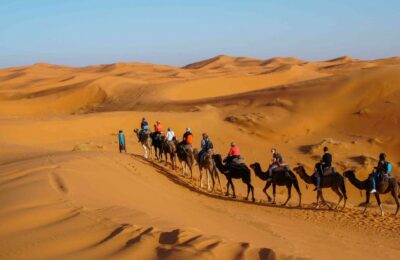 Sunset view of the majestic Erg Chebbi sand dunes in Merzouga, Morocco, with vibrant hues reflecting off the shifting desert landscape.