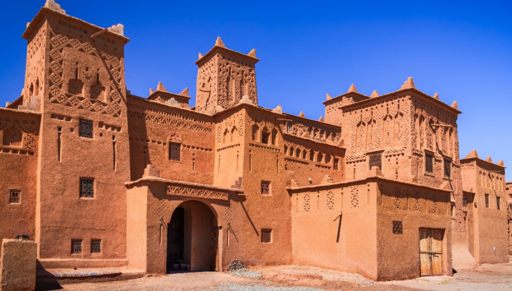 Taourirt Kasbah in Ouarzazate, Morocco, a historic mudbrick fortress with traditional Berber architecture under a blue sky