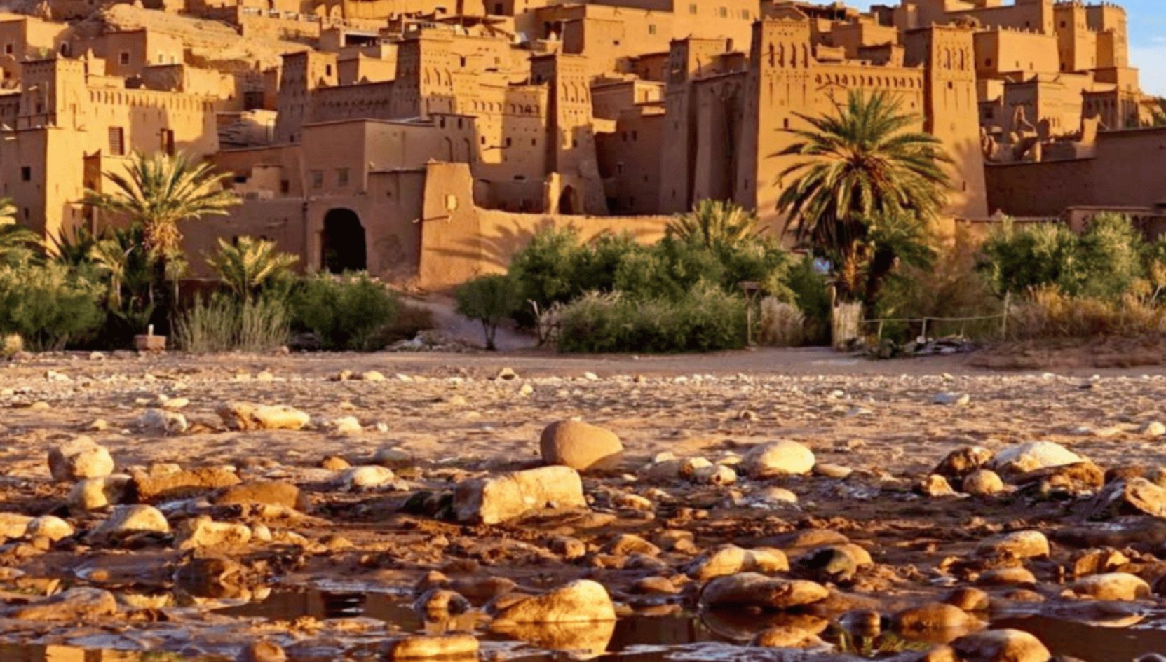Aït Ben Haddou kasbah in Ouarzazate, Morocco, a traditional earthen fortress surrounded by palm trees and desert scenery