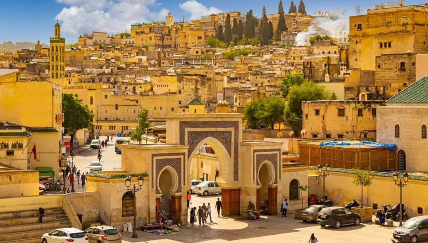 Bab Bou Jeloud gate in Fez, Morocco, with the old Medina and golden city buildings in the background.