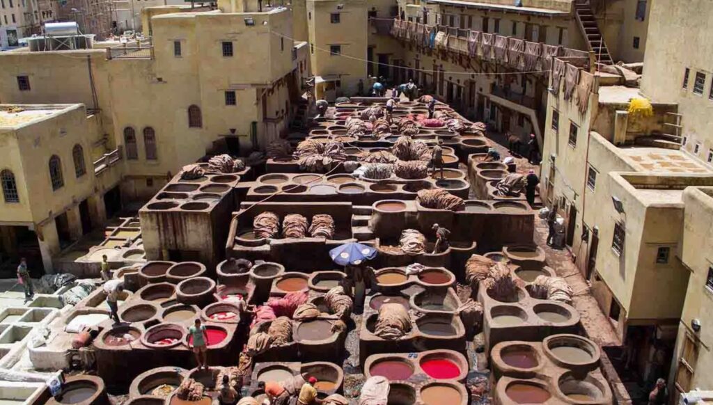 Workers dyeing leather at the Chouara Tannery in the old Medina of Fez, Morocco.