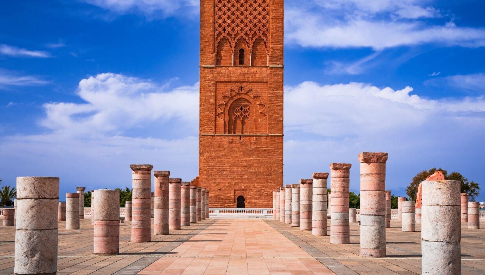 Hassan Tower in Rabat with stone columns of the unfinished mosque under a bright blue sky.