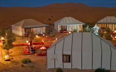 Night ambiance at Merzouga Luxury Desert Camp with glowing lanterns, tents, and cozy seating areas in the Sahara.