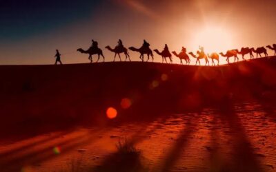 Silhouette of a camel caravan crossing the Sahara dunes at sunset in Merzouga, Erg Chebbi, and Chegaga