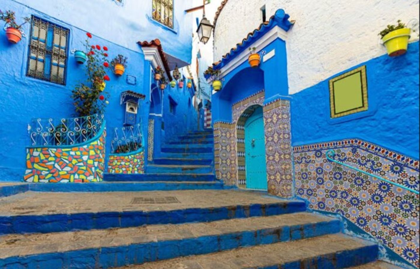 Vibrant blue stairs and colorful mosaic walls in the medina of Chefchaouen, Morocco.