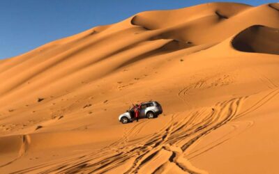 4x4 vehicle driving through the golden sand dunes of Merzouga in the Erg Chebbi desert