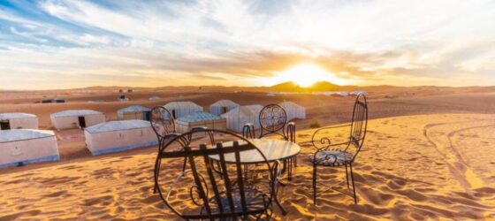 Luxury desert camp at sunrise in Merzouga, Chegaga, and Erg Chebbi with traditional seating on sand dunes