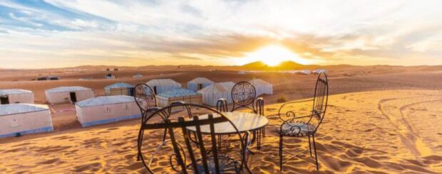 Luxury desert camp at sunrise in Merzouga, Chegaga, and Erg Chebbi with traditional seating on sand dunes