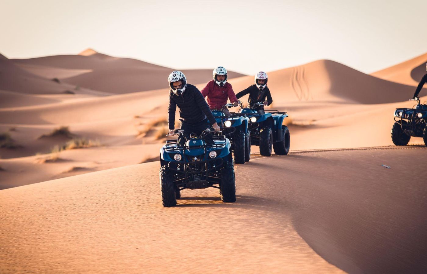 Group riding quad bikes across the sand dunes of the Merzouga Sahara Desert